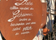Schild "Die Liebe allein versteht das Geheimnis, andere zu beschenken und dabei selbst reich zu werden "